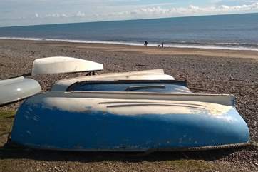 Little boats pulled up on the beach at Branscombe. An unspoilt coastal village with two family-friendly pubs, a National Trust cafe, beach cafe and shop and beachside parking.