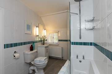 This is the family bathroom. The door to the cottage is behind the half wall at the end of the bath. There is a family shower room too - with the same fresh design and a huge walk in shower