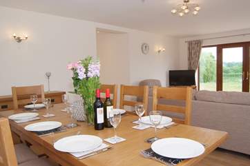The very large sitting/dining room with French doors to the patio, garden and lake beyond. The garden is fully fenced. The hot tub is just around to the right hand side in its own open fronted little
