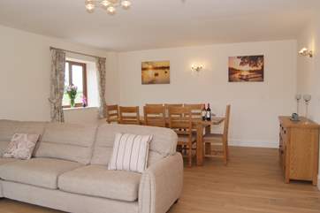 The dining table is at the far end of this lovely bright and spacious room.