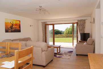The living/dining room has French windows to the patio and garden and lovely country and lake views