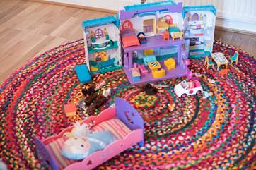 The twin bedroom has a play area, toys and boxes.