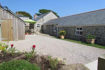 The sunny rear courtyard showing the secure storage shed to the left, ideal for bikes, surfboards and beach gear.