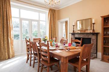 The stunning dining-room has a large table seating 8 with patio doors opening up to the garden and pool area