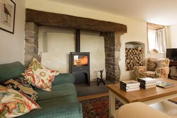 The wood-burning stove is a real focal point in this room - as is the alcove stacked full of logs for you.