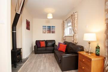 The cosy living area features a log burner, ideal for winter breaks.