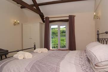 The double bedroom, with itssuper king size bed, is dual aspect - the sea one side and fields to the other.