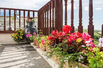 The planters on the balcony full of pretty flowers.