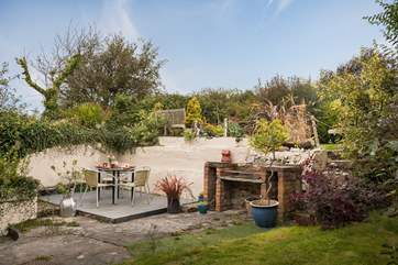 The enclosed patio has a built-in barbecue. The owners' garden is situated above, and the owners do enjoy using this area.