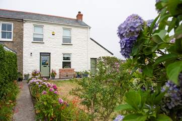 An enclosed front garden leads to the cottage.