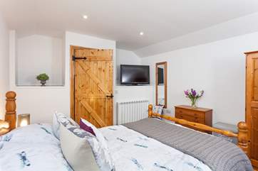 The bright and airy master bedroom, has a double bed.