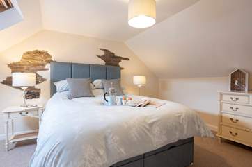 The bedroom is in the eaves and has sloping ceilings.