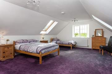 The light and sunny family bedroom (Bedroom 3) with a double and single bed, and en suite bathroom.
