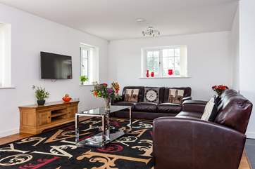 The open plan living-room with kitchen and dining areas has lots of sofa seating.