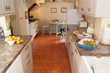 The galley style kitchen has space for a breakfast table next to the lovely warm Rayburn, and French windows out to the garden.
