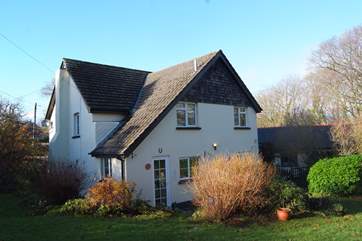 This is a view of The Cottage from the enclosed garden. Up to 5 dogs are welcome. The separate paddock is behind the little outbuildings to the right of the picture.