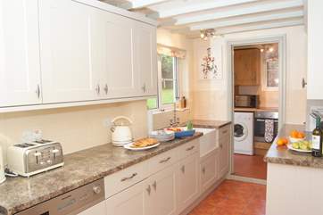 A view of the kitchen from the other direction. There is an additional electric oven and hob in the utility-area at the far end, and another back door to the garden.