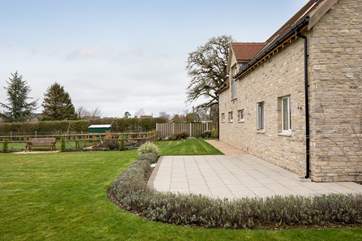 The patio has furniture and a gas barbecue for lazy al fresco dining in the summer. The owner's home is behind and to the right.