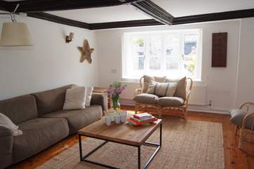 There is a warmly welcoming living room with a wood burning stove ini the large fireplace and a beamed ceiling which celebrate the age of the property