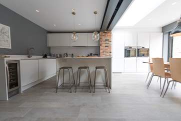 The sleek contemporary kitchen is beautifully equipped - even with a wine-chiller - for your stay.