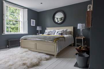 The master bed room has a super-king sized bed. Painted flooboards are balanced with the thick sheepskin rug.