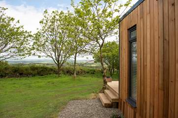 There are stunning far-reaching views over countryside out to the sea in the distance.
