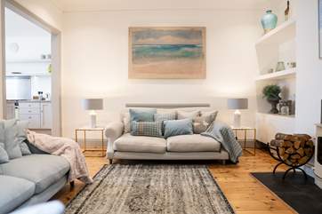 The open plan living area adjoins the kitchen and a wood-burner keeps it snug in winter.