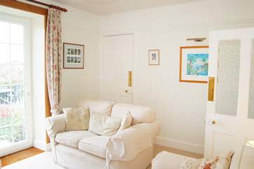 The sitting-room is flooded with light through the door out to the garden.