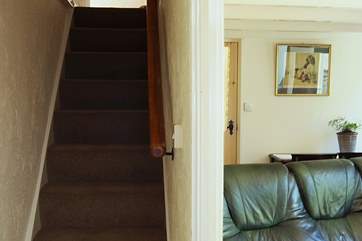 A typical cottage staircase leads from the sitting-room to the first floor bedrooms and bathroom.