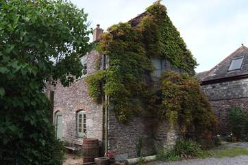 The exterior of this pretty barn with the stone steps leading up to the front door.