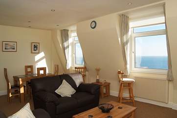 The light, sunny sitting/dining-room has wonderful sea views.