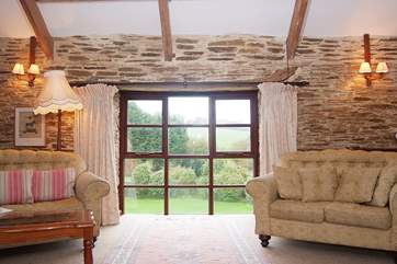 Floor length windows in the sitting-area look out over lovely gardens.