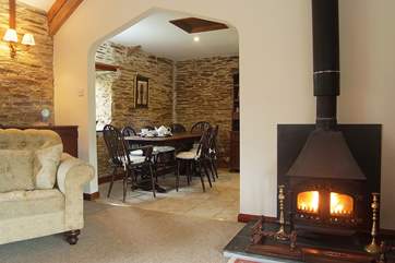The lovely wood-burner in the sitting-area, looking through into the dining-area.