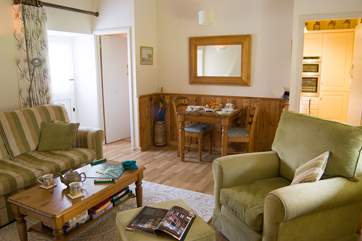 The dining-table is tucked away at one end of the sitting/dining-room and the stable-door opens onto the shared garden.