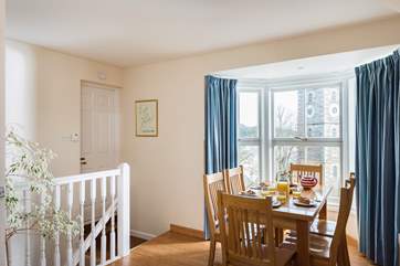 The dining table sits in the window bay.